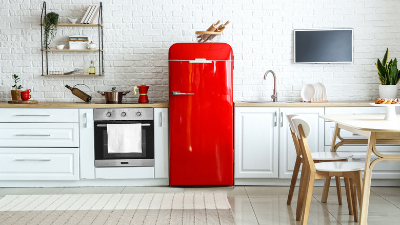 interior of white kitchen with red retro fridge