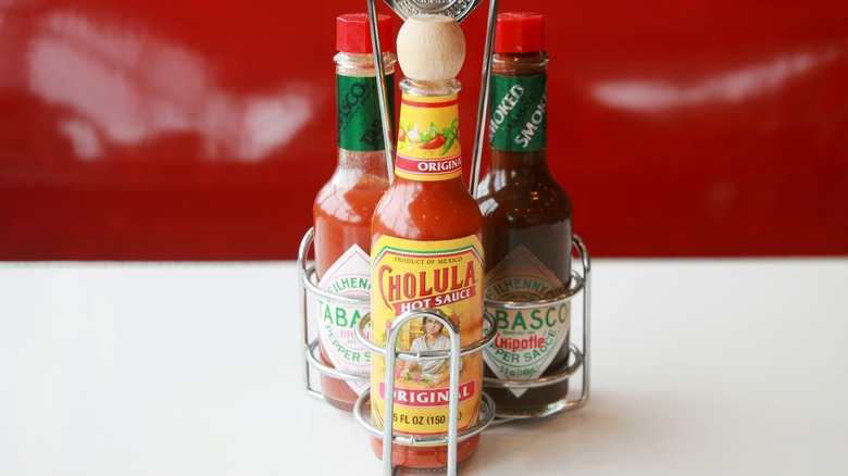 Hot sauces in caddy on restaurant table