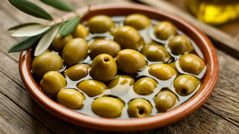 Olives in ceramic dish of olive oil