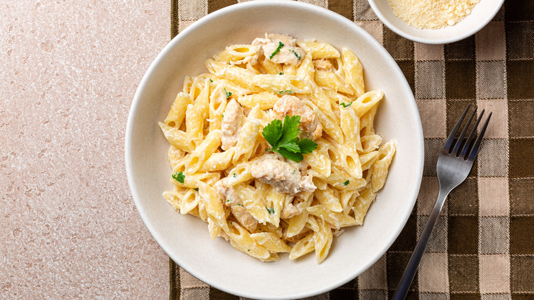 A bowl of alfredo pasta with chicken and creamy alfredo sauce