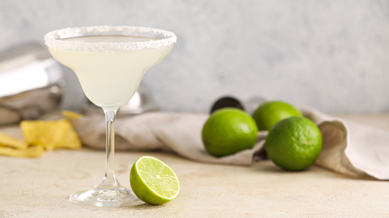 A margarita with salt rim and limes