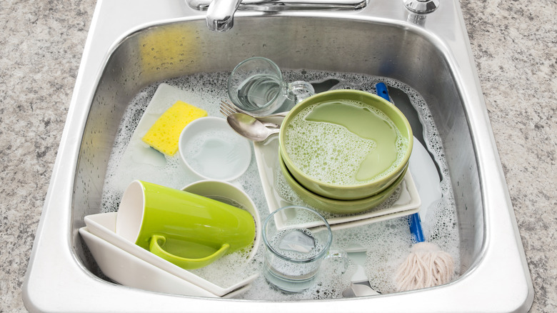 Dishes soaking in soapy water in a sink
