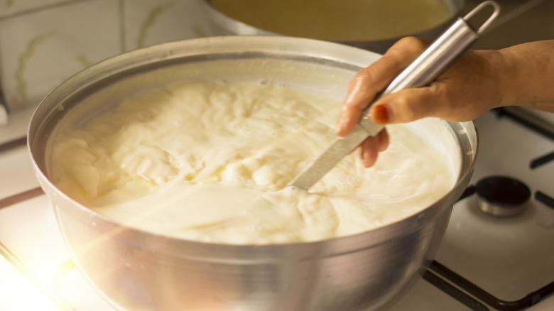 A metal bowl on a stove full of homemade yogurt