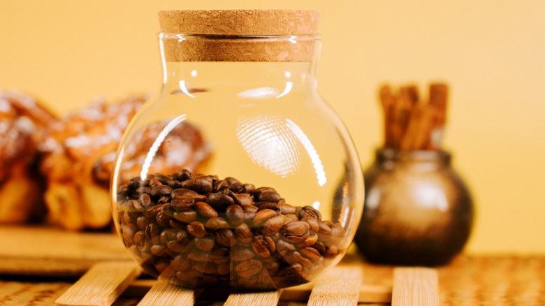 Glass jar holding coffee beans on countertop