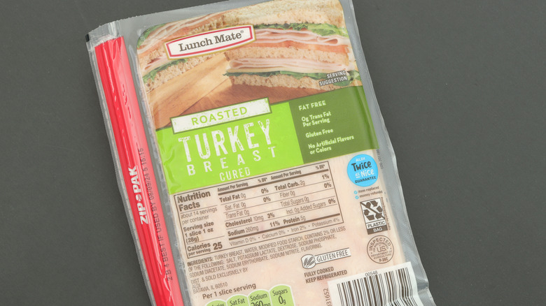 Lunch Mate brand sliced turkey breast isolated against dark background.
