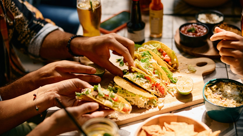 People sharing a taco platter at a Mexican restaurant