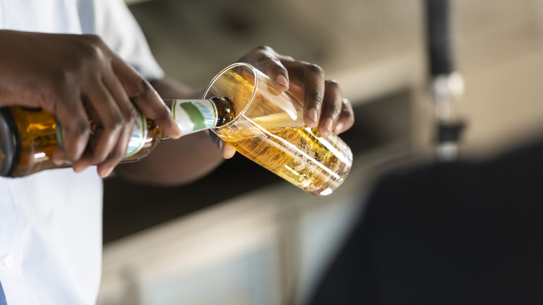 A man pours fresh beer into a glass