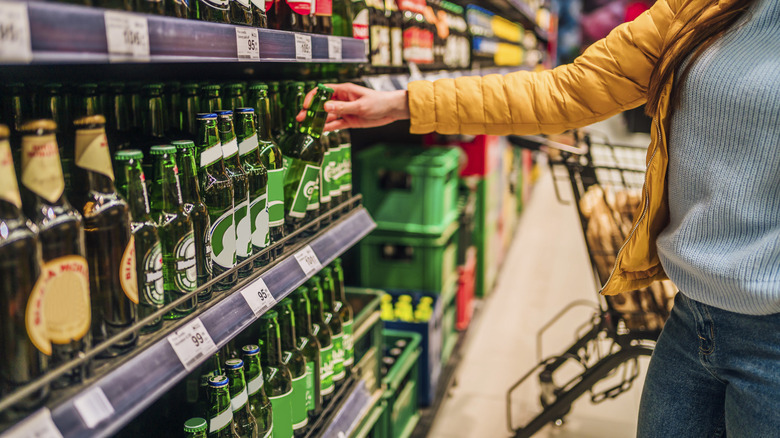 A woman grabs room temperature bottle of beer