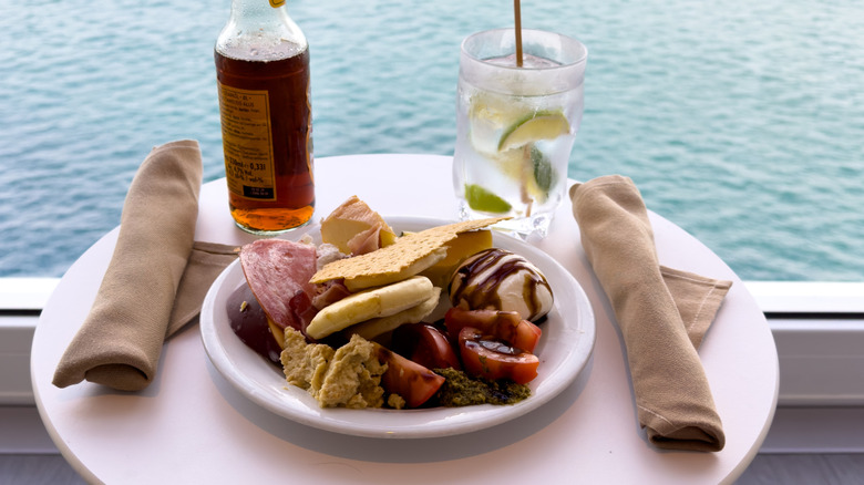 A cruise ship charcuterie plate on a deck overlooking the ocean