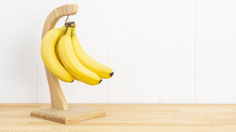 Bananas hanging on wooden banana hook