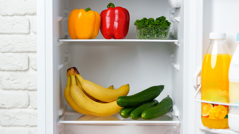 Bananas in fridge with cucumbers, peppers, parsley, juice