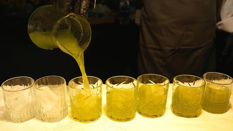 Bartender pouring cocktails into rocks glasses from pitcher