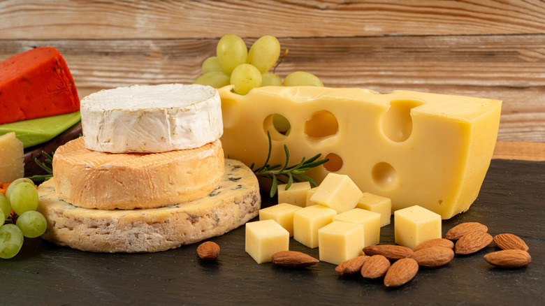 Different styles of cheese next to green grapes