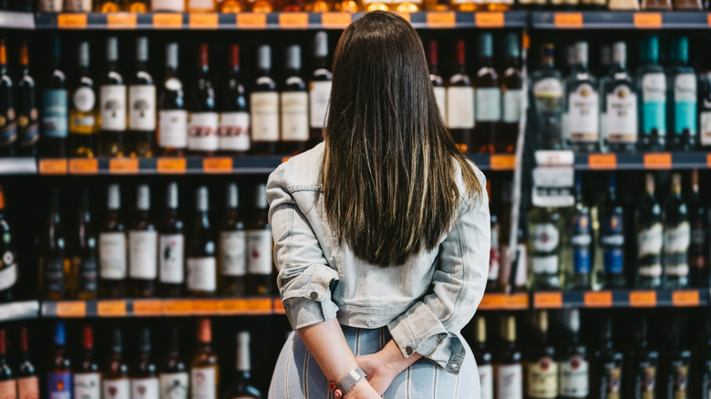 Person looking at a shelf of spirits
