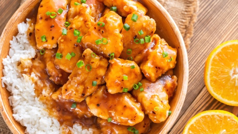 A bowl of orange chicken with white rice.