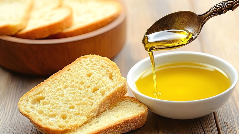 Olive oil being drizzled over toasty pieces of bread.