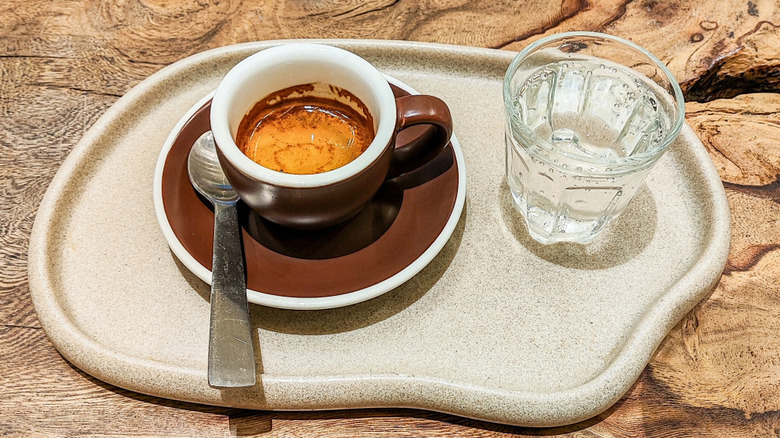 Shot of espresso and small glass of sparkling water