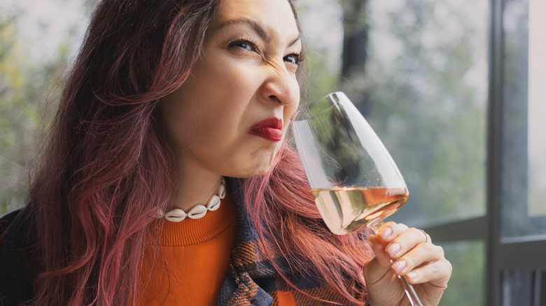 A young woman sniffing some bad juice!