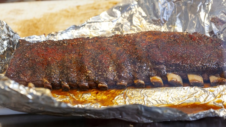 Rack of ribs in aluminum foil just out of the smoker