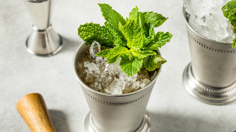 Mint leaves in mint julep in two mint julep cups.
