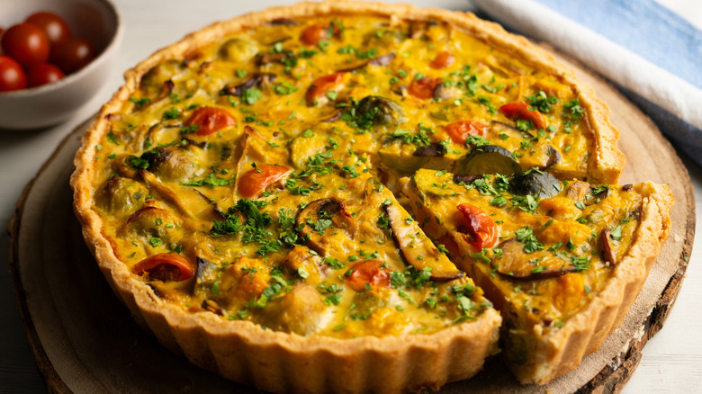 vegetable quiche on a slice of tree stump