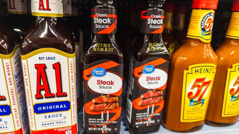 Three brands of steak sauce on a store shelf