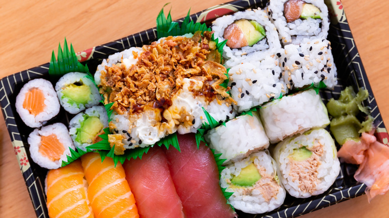 Takeout container of sushi rolls and sushi grass