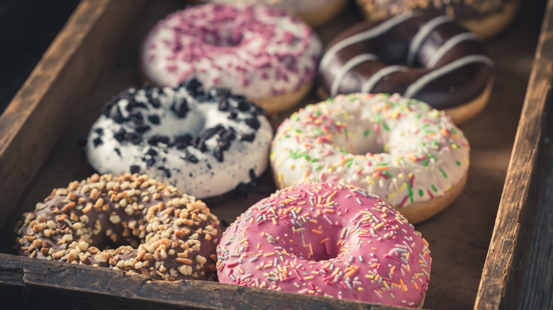A group of interestingly flavored donuts on a tray