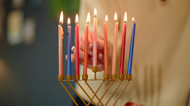 Woman lighting Hanukkah menorah