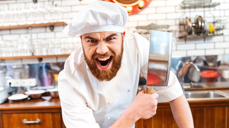 Angry bearded chef holding butcher knife