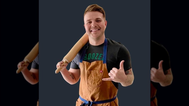 Chef Brandon Frohne holding a rolling pin and posing for the camera