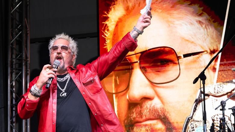 Guy Fieri in front of a backdrop of Guy Fieri at an event