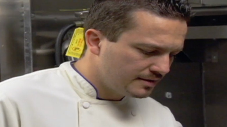 Chef Fabio Viviani looking down at his broken finger getting wrapped up by a medic