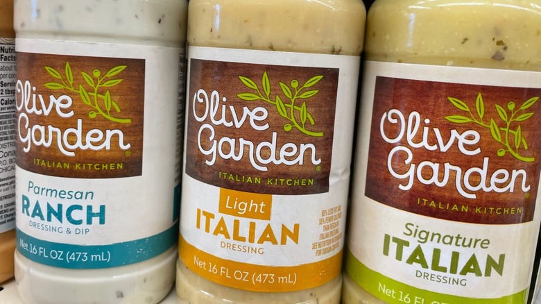 Labels for bottles of Olive Garden dressing varieties on grocery shelf