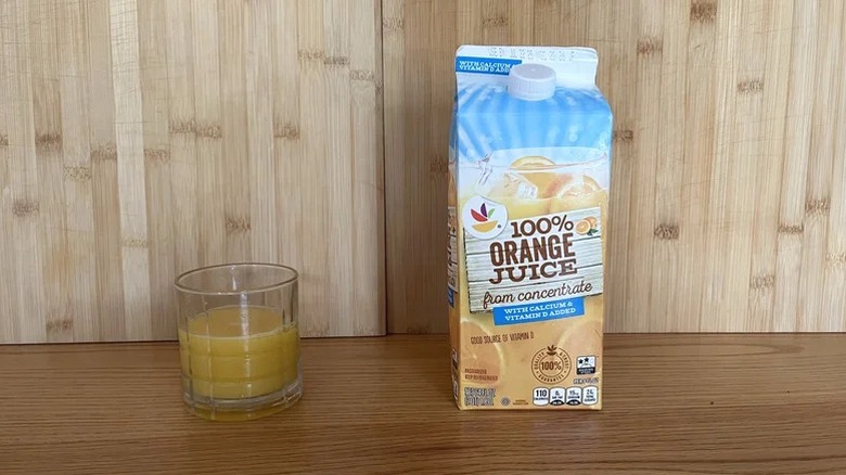 A carton of Stop & Shop orange juice next to a poured glass