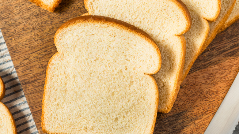 Slices of bread on a wooden cutting board.