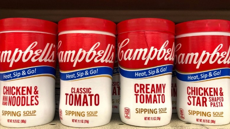 Several Campbell's soups on a shelf, including Creamy Tomato.