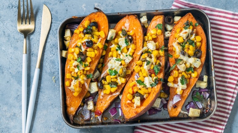 Baked sweet potato halves stuffed with corn, olives, cilantro, onion, and seasonings
