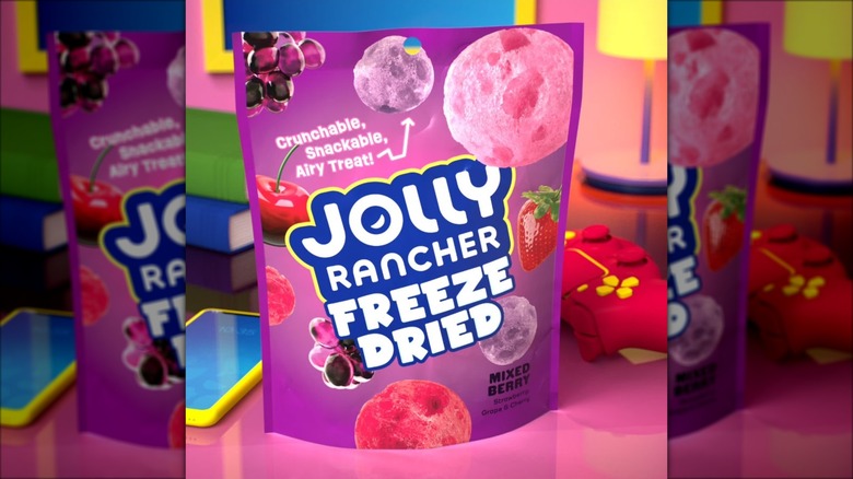 A snack bag of freeze dried Jolly Ranchers on a colorful background.