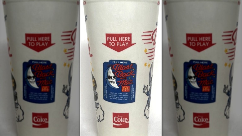 a Black Back With Mac cup with a game piece on it