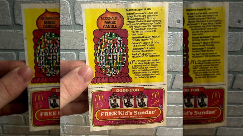 a hand holding a McDonald's Magic Candle card