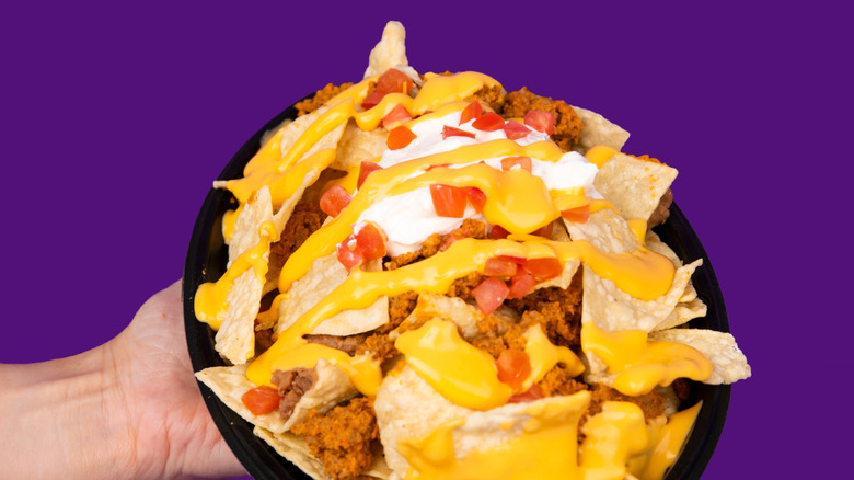 Plate of loaded nachos with a side of salsa