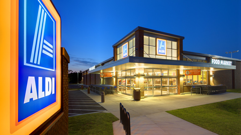 An exterior shot of an Aldi with sign showing, all lit up at night