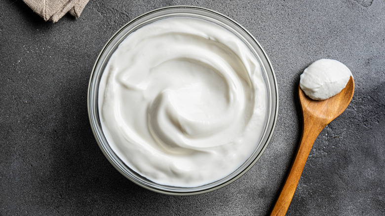 A bowl of Greek yogurt with a wooden spoon