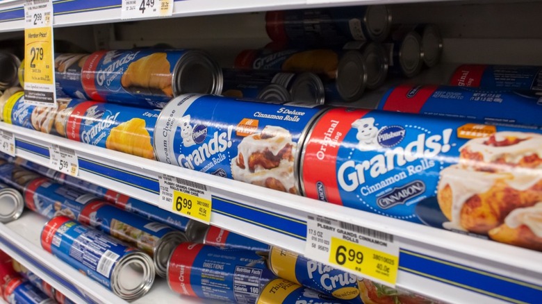 Pillsbury brand cinnamon rolls sitting on a refrigerator shelf.