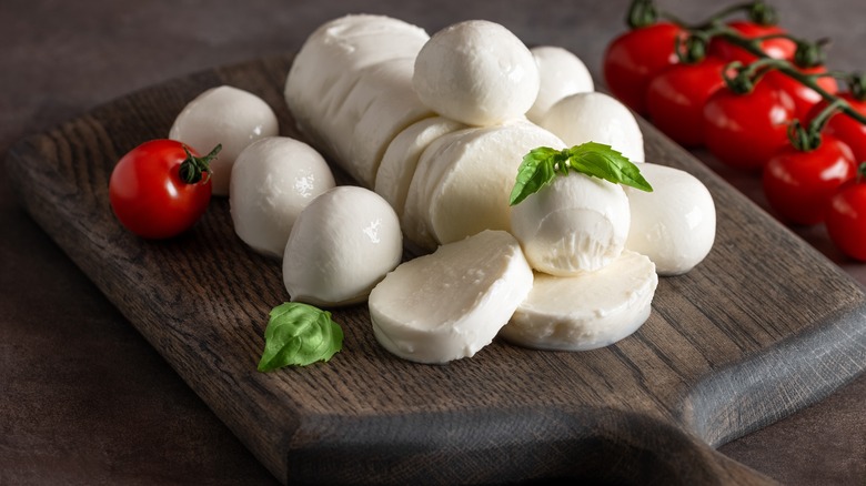 fresh mozzarella on a wooden board with tomatoes