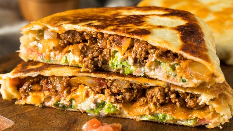 A beef-filled Taco Bell Crunchwrap Supreme cut in half