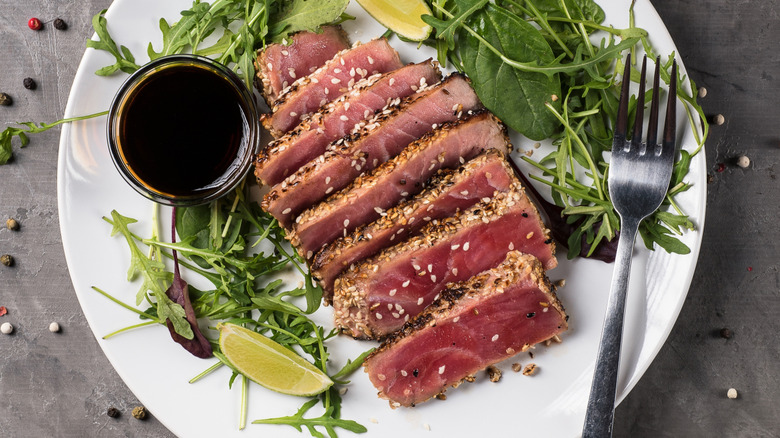 Sliced tuna steak with sesame seeds and fresh greens