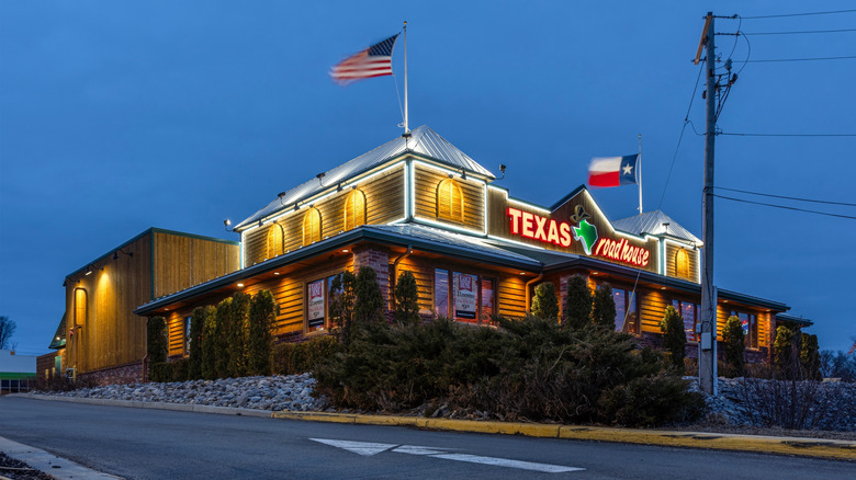 The lit outside of Texas Roadhouse at night.