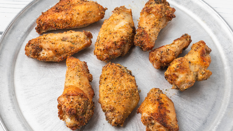 Dry-seasoned chicken wings on pizza tray.